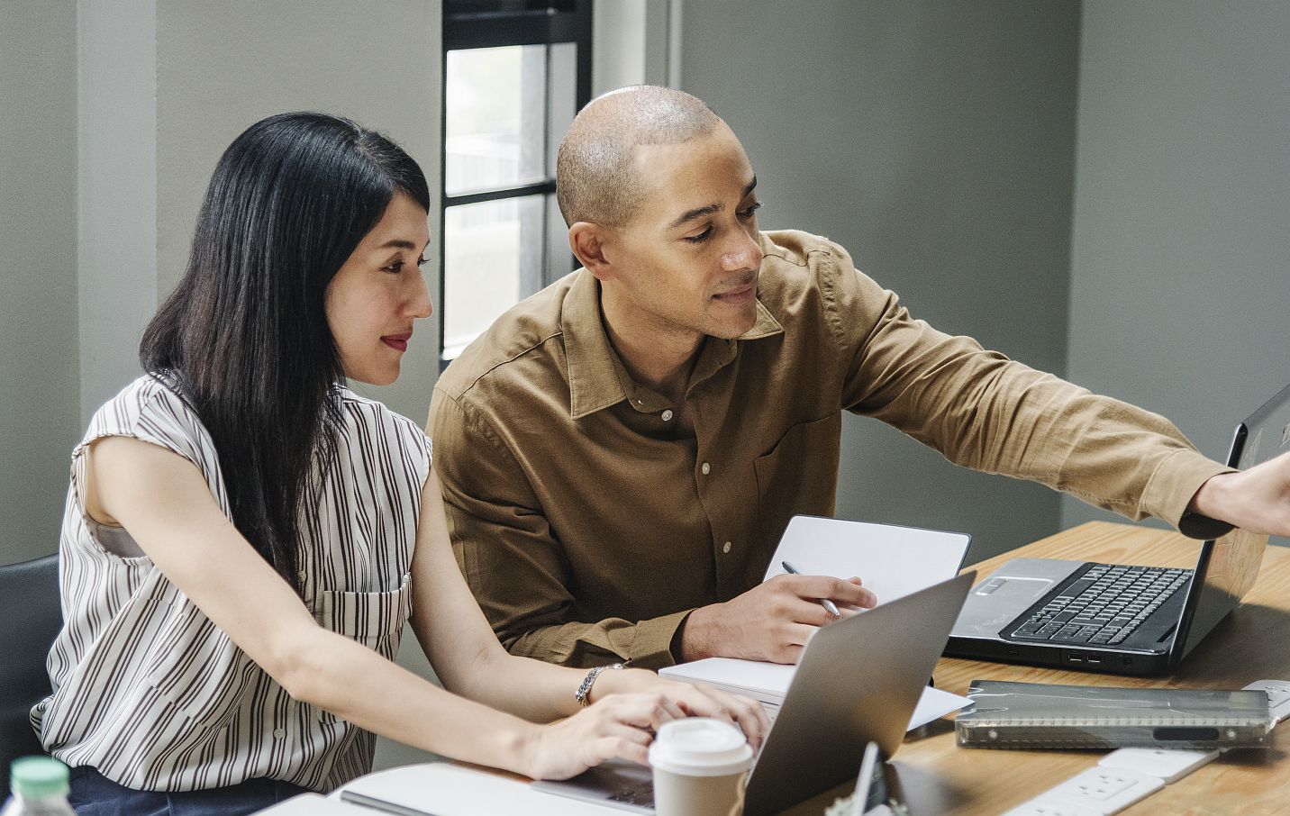Two people working and looking at laptops.
